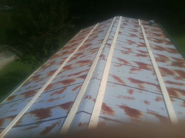 Rusted metal roof panels with new wood purlins before replacement — Storm Damage Roof Repair in Gifford by Roofing Brothers